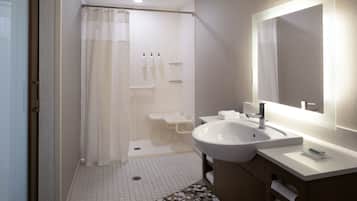 A modern bathroom with a shower, sink, and mirror.