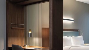 Une chambre d’hôtel équipée d’un bureau, d’une chaise et d’un lit.