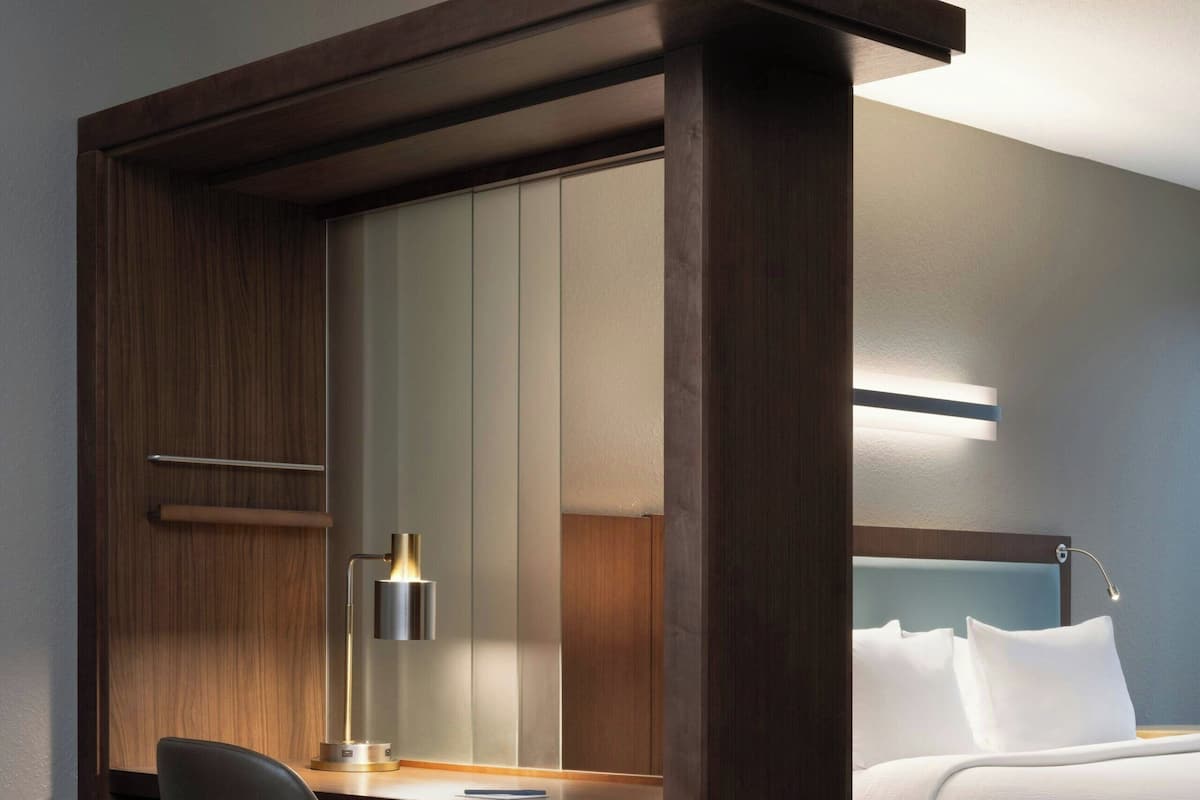 Une chambre d’hôtel équipée d’un bureau, d’une chaise et d’un lit.