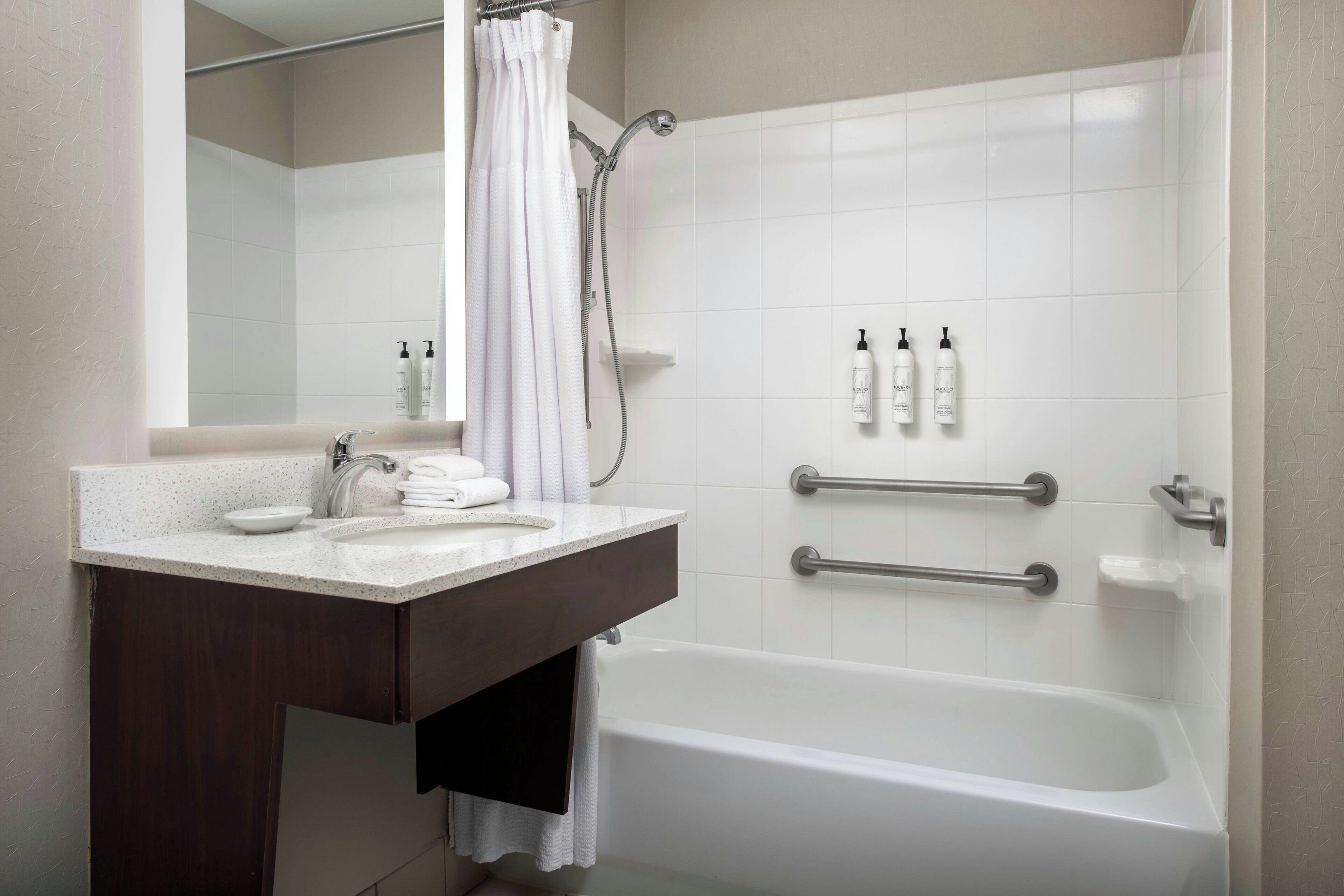 A modern bathroom with a bathtub, a vanity with a sink, and a shower area.