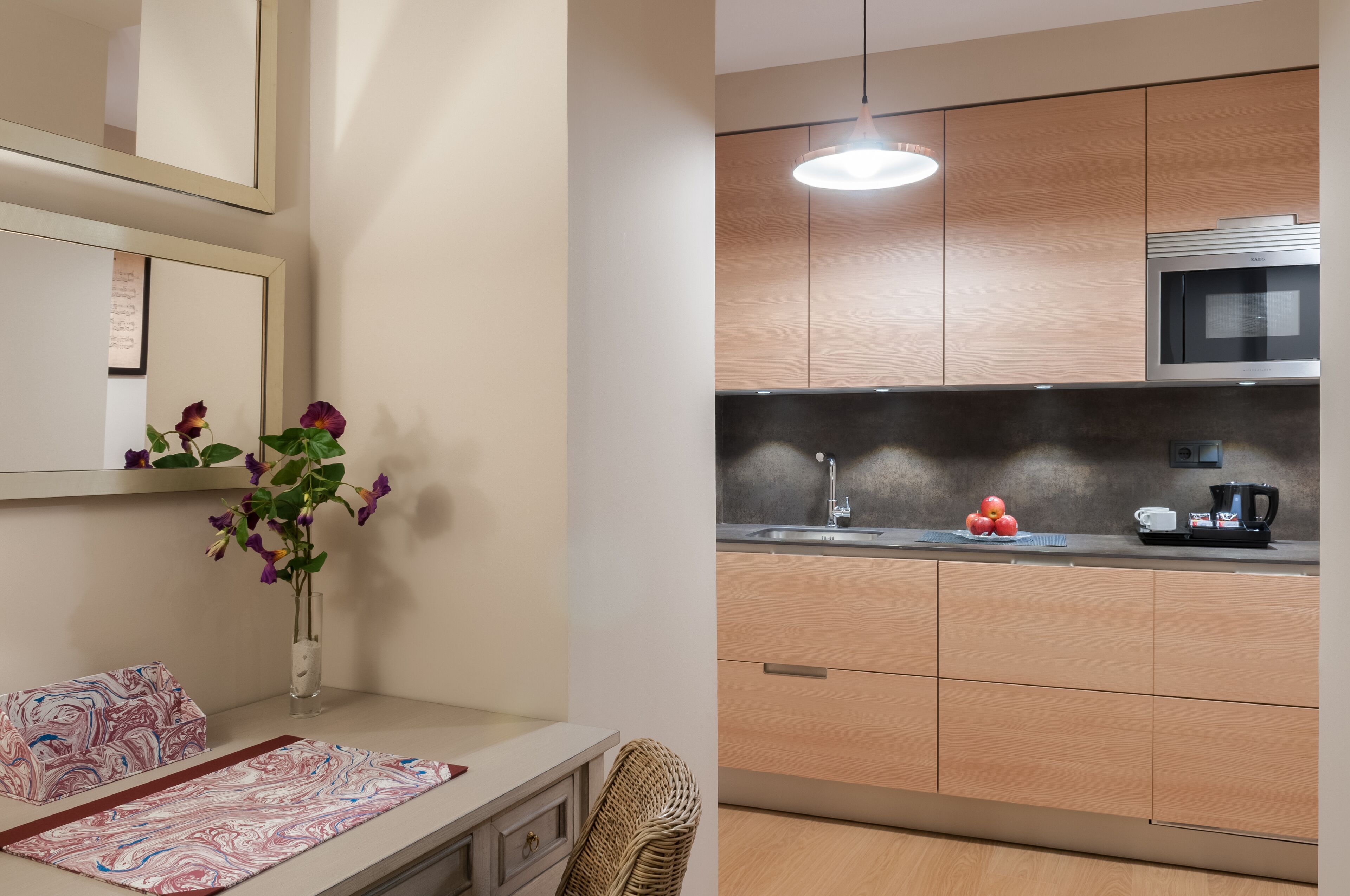 A modern kitchen with wooden cabinets, a stainless steel microwave, and a sink.