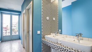 A bathroom with two sinks, a mirror, and patterned tiles. - Mola Hostel (Madrid)