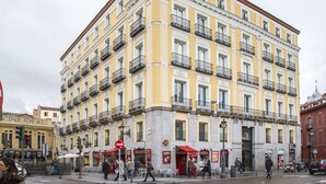A multi-story building with balconies, a café, and a restaurant on the ground floor. - Mola Hostel (Madrid)