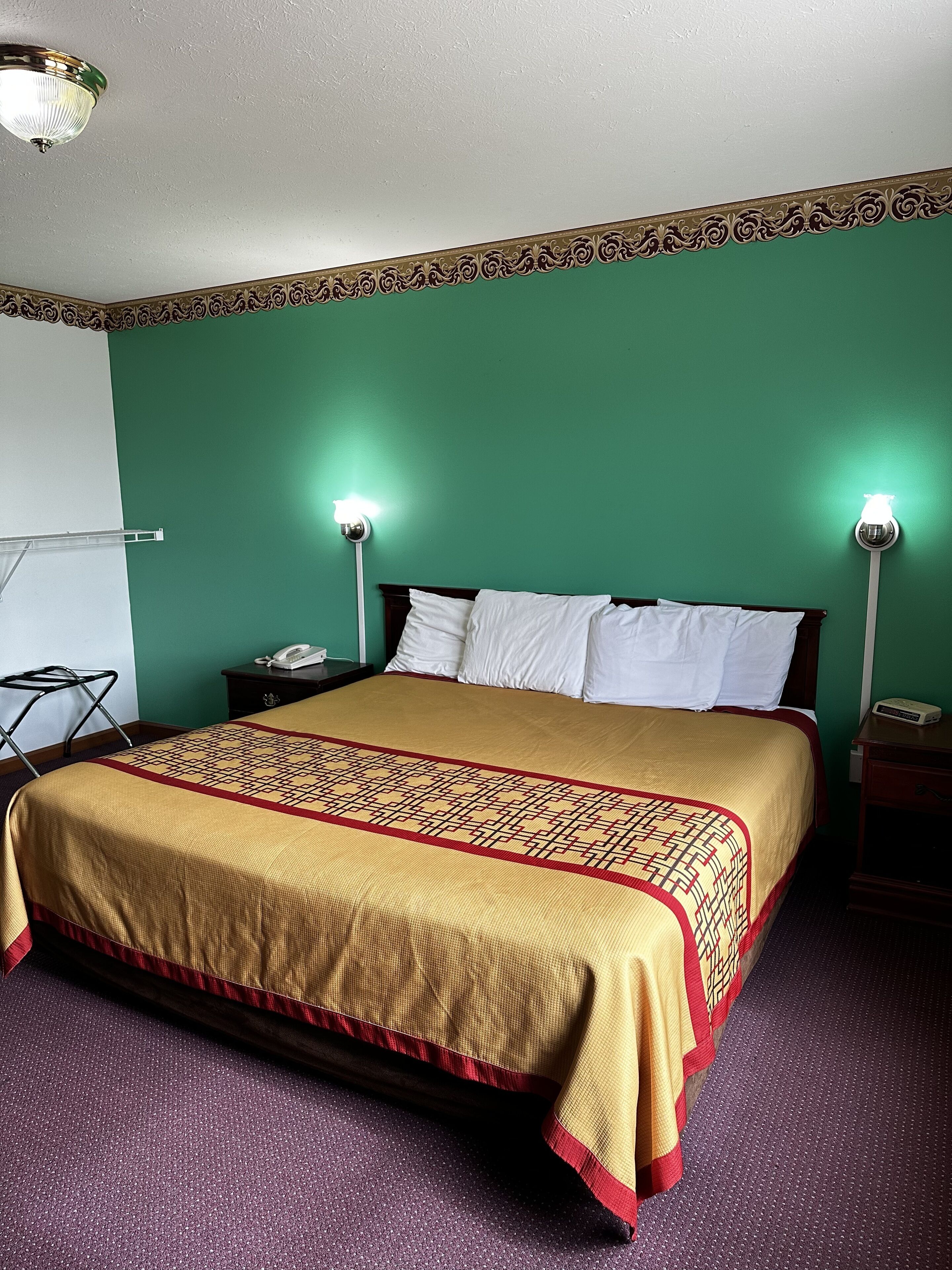 Une chambre d’hôtel comprenant un lit, deux lampes de chevet, une table de chevet, un téléphone et une chaise.