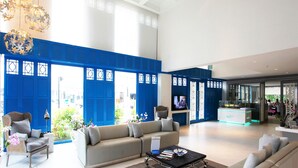 A spacious lobby with a high ceiling, a sofa, a coffee table, and a reception desk. - My Resort HuaHin E503 (Hua Hin)