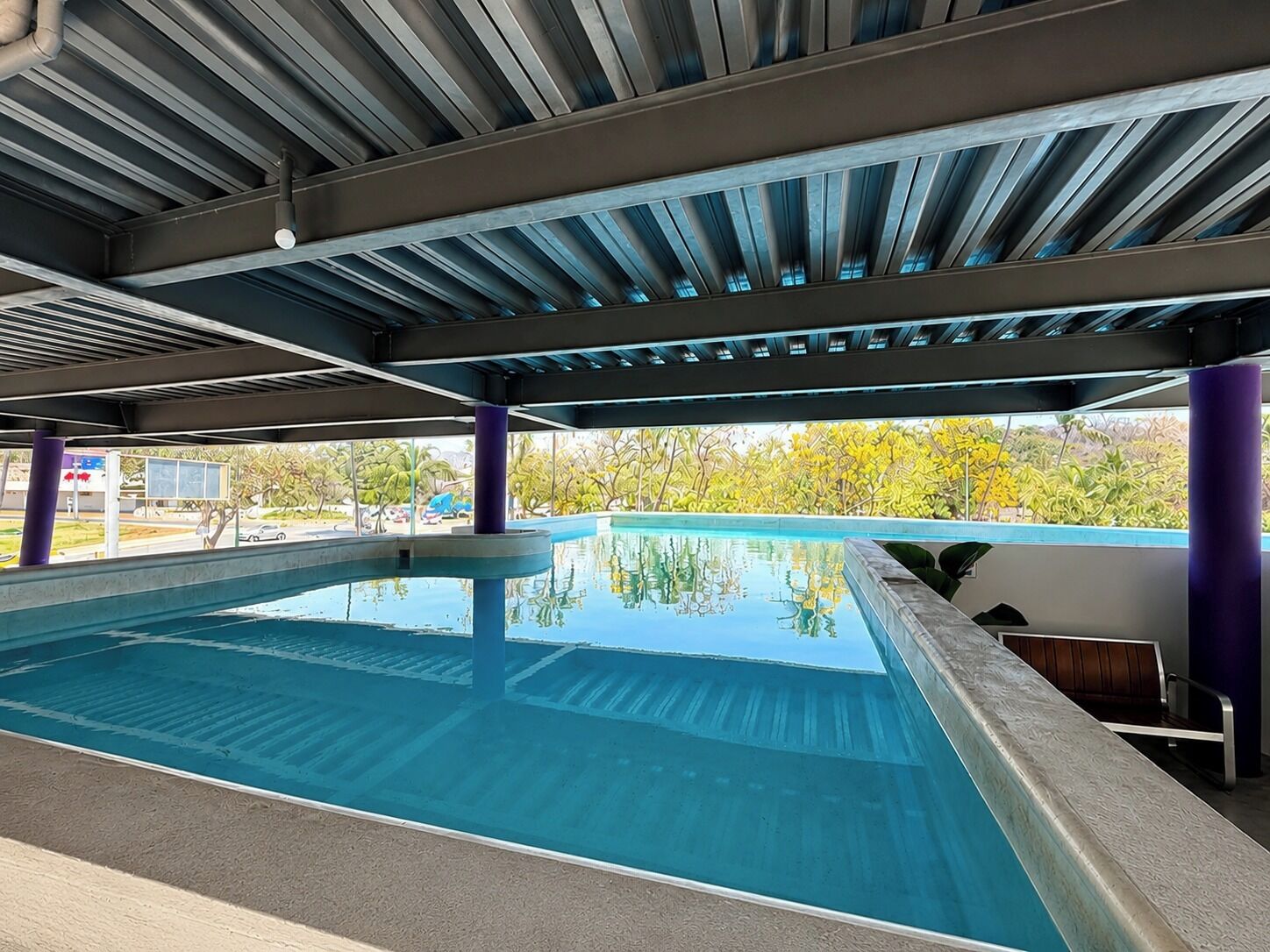 Una piscina al aire libre, sillones reclinables de piscina