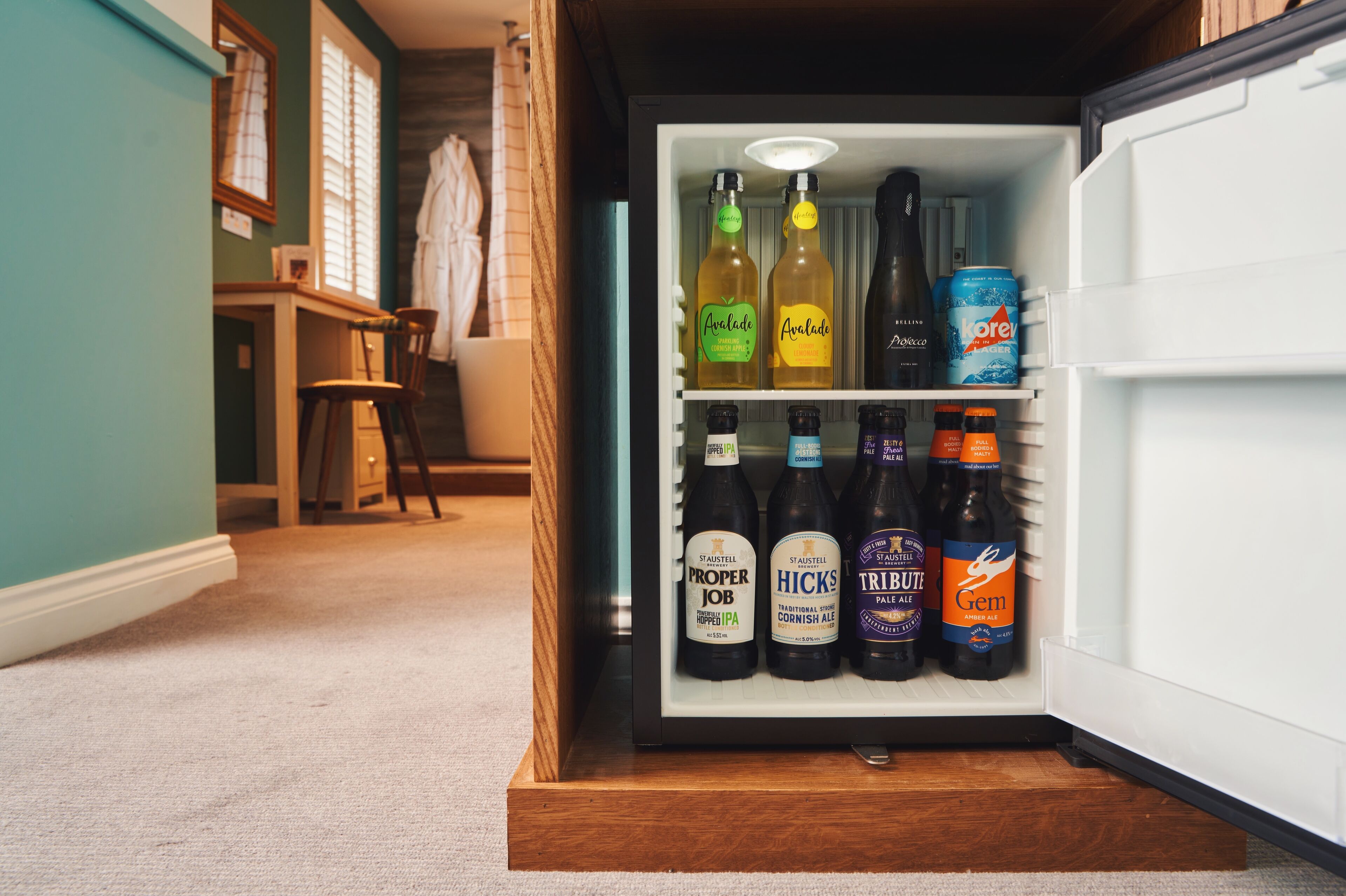 A refrigerator stocked with various beer bottles and a can.