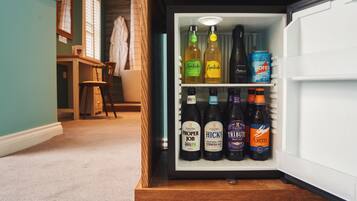 A refrigerator stocked with various beer bottles and a can.