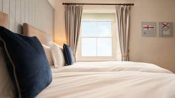Une chambre à coucher avec un lit, des oreillers, une fenêtre avec des rideaux et des éléments de décoration murale.