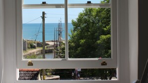 A window with a view of the sea and a tree. - Rashleigh Arms (St Austell)