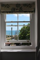Habitación doble superior, 1 cama de matrimonio grande, vistas parciales al mar | Escritorio, tabla de planchar con plancha, wifi gratis y ropa de cama