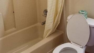 Un bagno con vasca, servizi igienici e tenda da doccia.