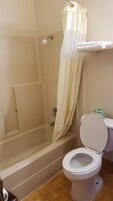 Un bagno con vasca, servizi igienici e tenda da doccia.