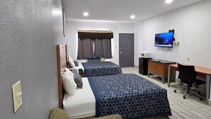 A hotel room with two beds, a desk, a TV, and a couch. - Executive Inn and Suites (Port Isabel)