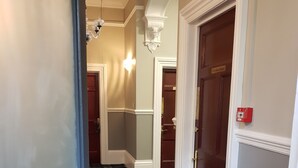 A hotel hallway with a checkered floor, a 'No Smoking' sign, and a fire alarm. - Kingswood (Stockton-on-Tees)