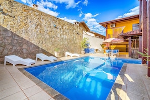 Een buitenzwembad en ligstoelen