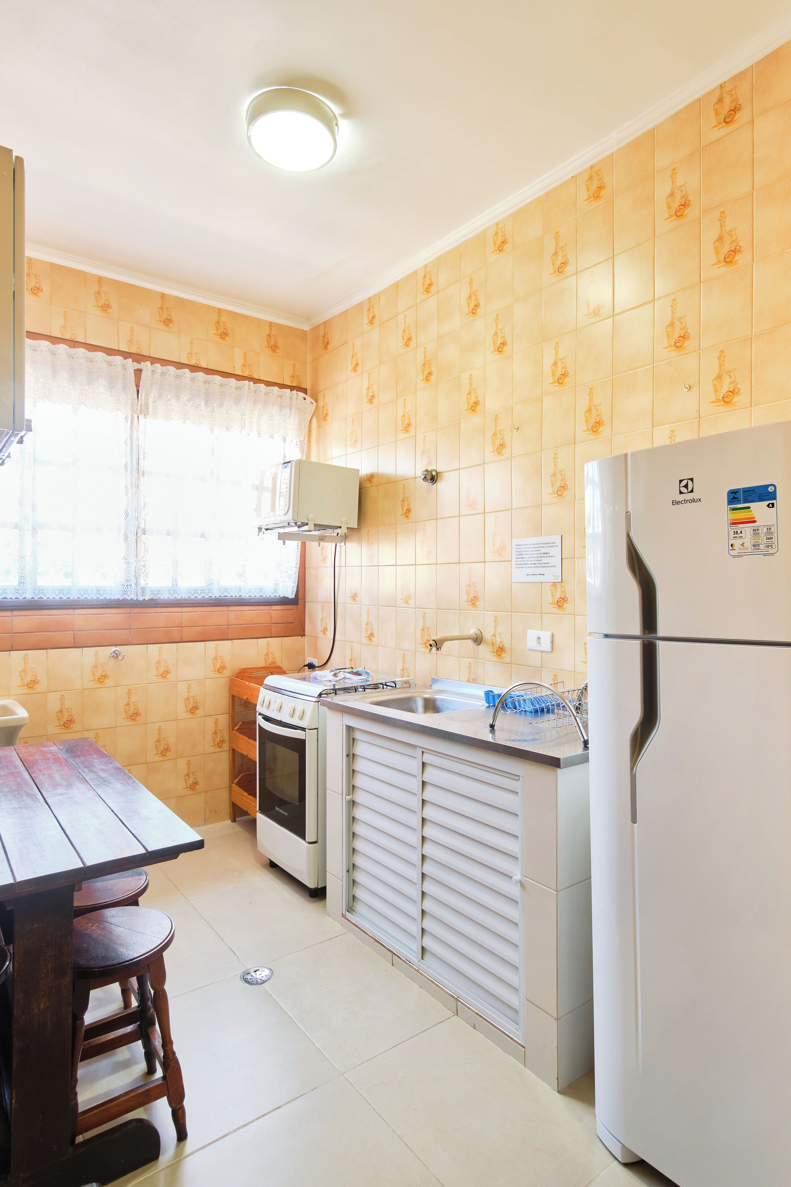 Eine kleine Küche mit Herd, Spüle und Kühlschrank.