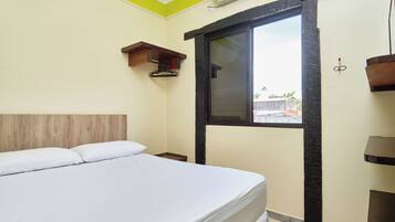 Un dormitorio con cama, ventana y cabecera de madera.