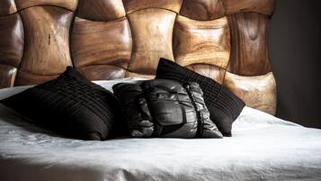 A bed with a wooden headboard and black pillows.