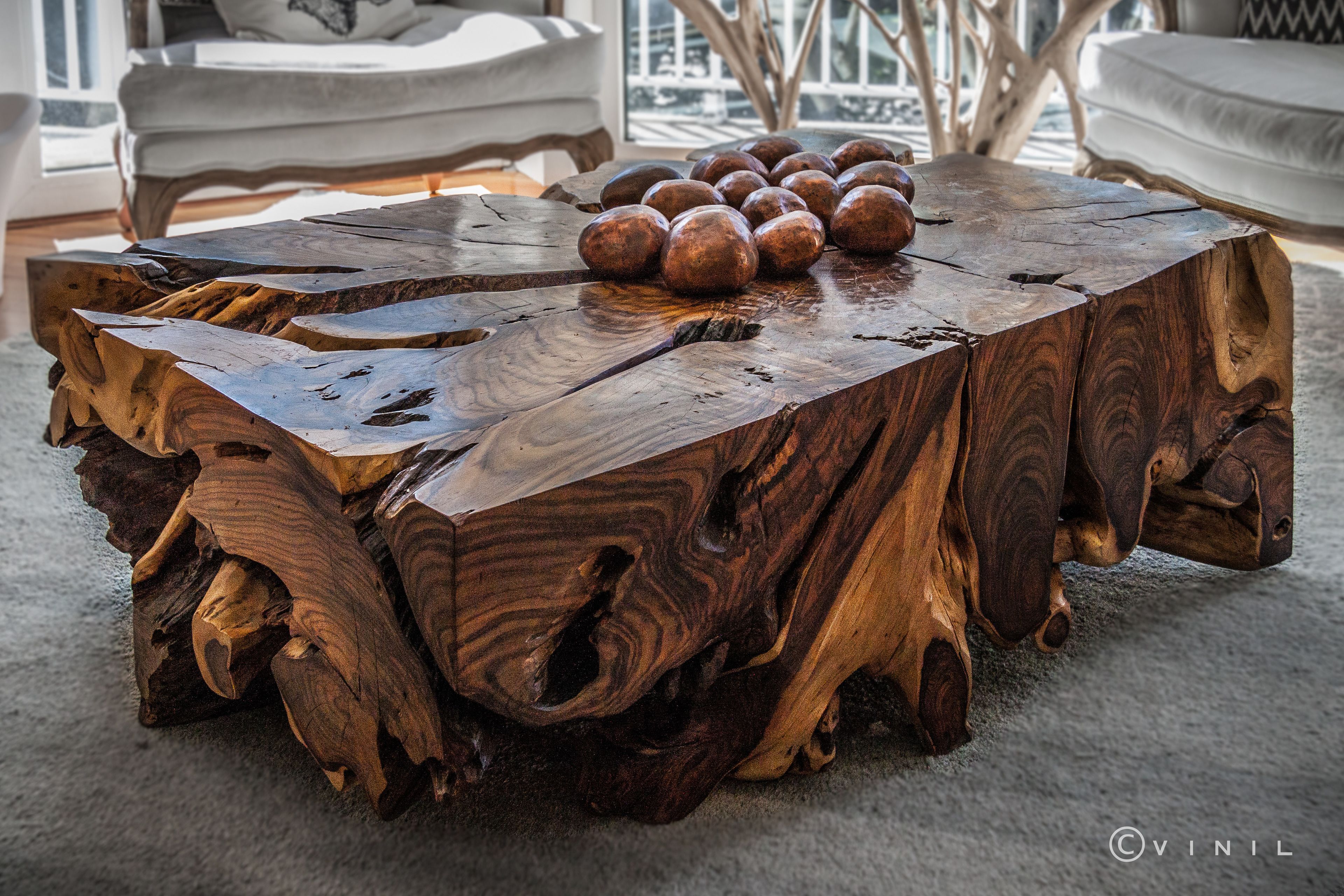 A rustic wooden coffee table with a natural finish and a unique, textured design.