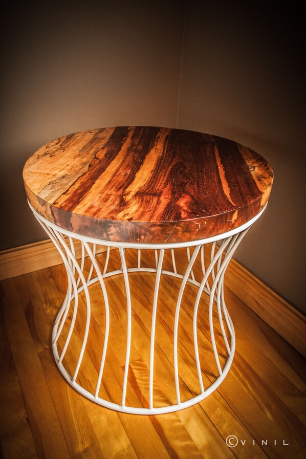 A round table with a wooden top and a white metal frame. - Villa Nao (Roxton)