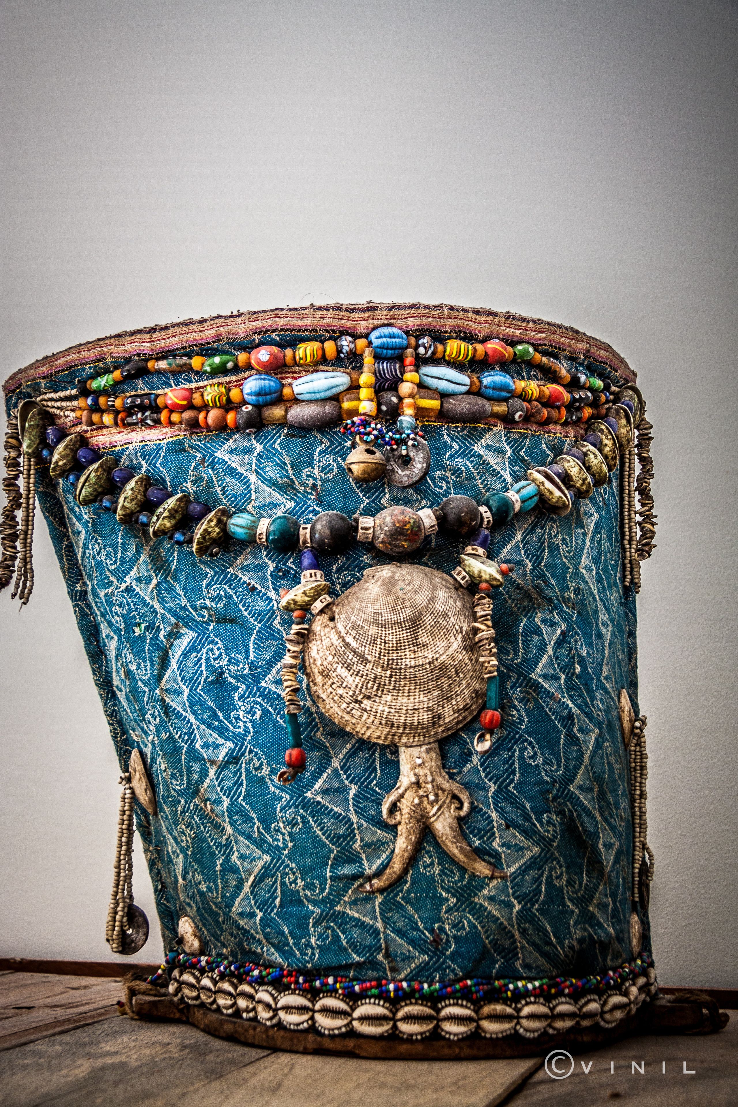 A drum with intricate beadwork and a decorative tassel.
