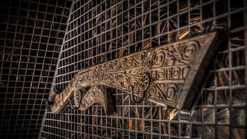 Et nærbillede af en metalrist med detaljerede mønstre og en dekorativ metaldetalje.