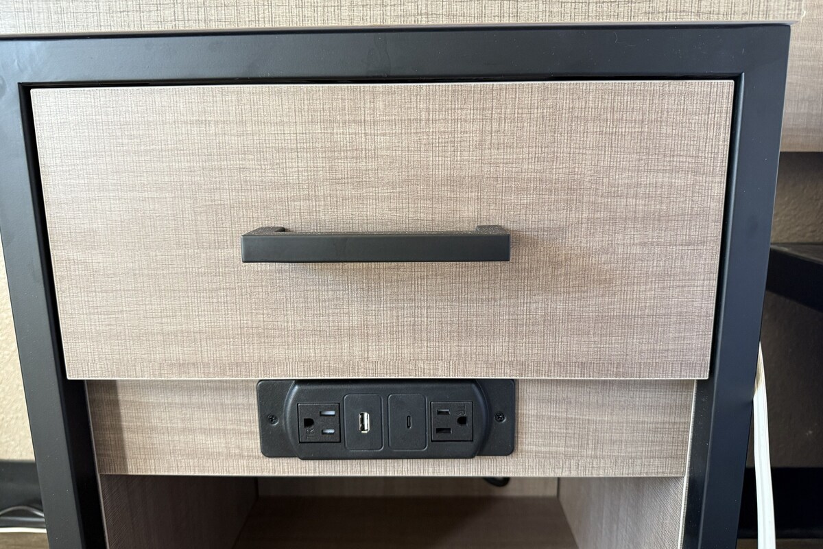 Un cajón con asa y un enchufe con puertos USB.