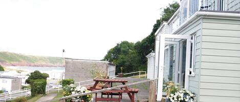 En terrasse med picnicborde og plantekasser.