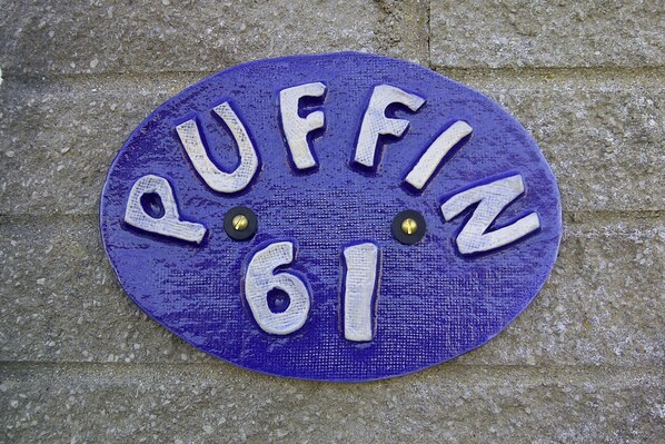 Un letrero circular con la inscripción 'PUFFIN 61'.