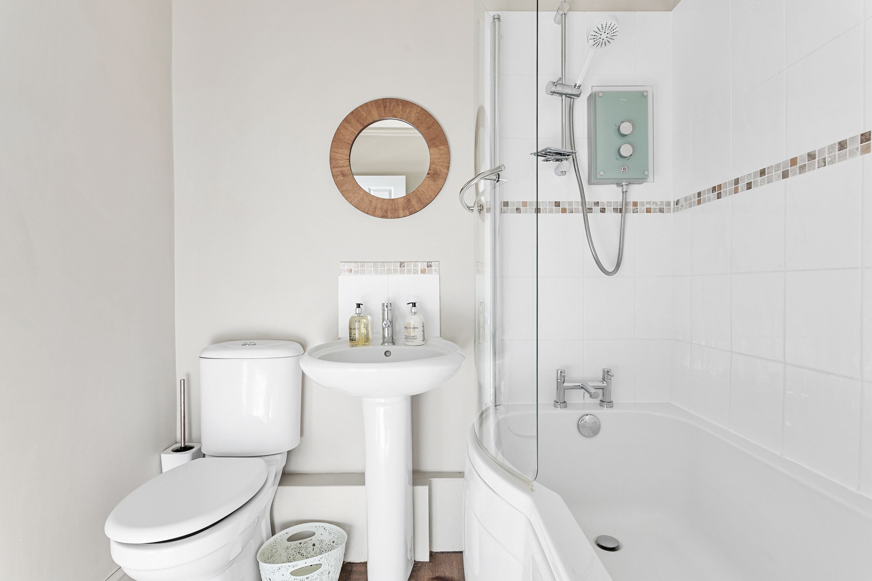 A modern bathroom with a toilet, sink, and shower.