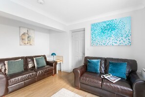 Relax in this stylish living room with two comfortable sofas, a floor lamp, and a side table.
