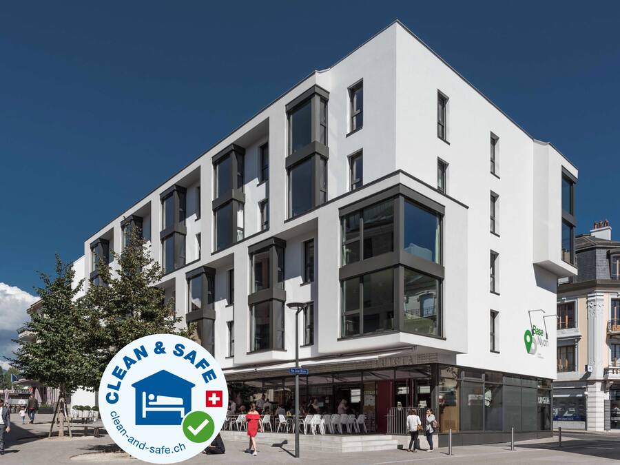 A modern building with a clean and safe logo, featuring a checkmark and a house icon.