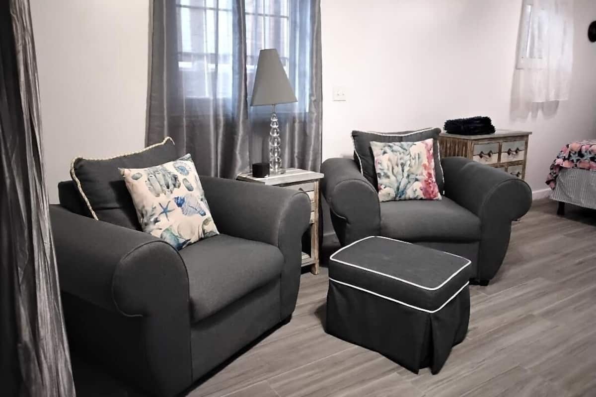 A modern living room with two sofas, a side table, and a lamp.