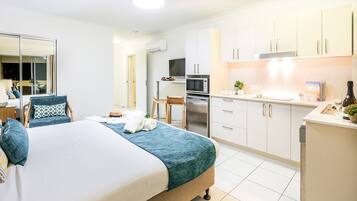 Et moderne hotelværelse med en stor seng, et tekøkken og et badeværelse.