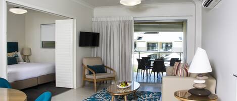 Habitación de hotel con cama, una silla, una mesa, una lámpara y vistas al exterior.