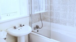 A bathroom with a toilet, sink, and bathtub. - Millie and Charley's Apartments (Londonderry)