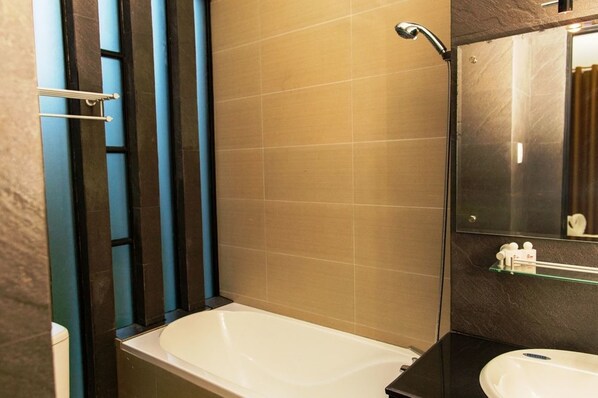 A modern bathroom with a bathtub, a sink, and a mirror.