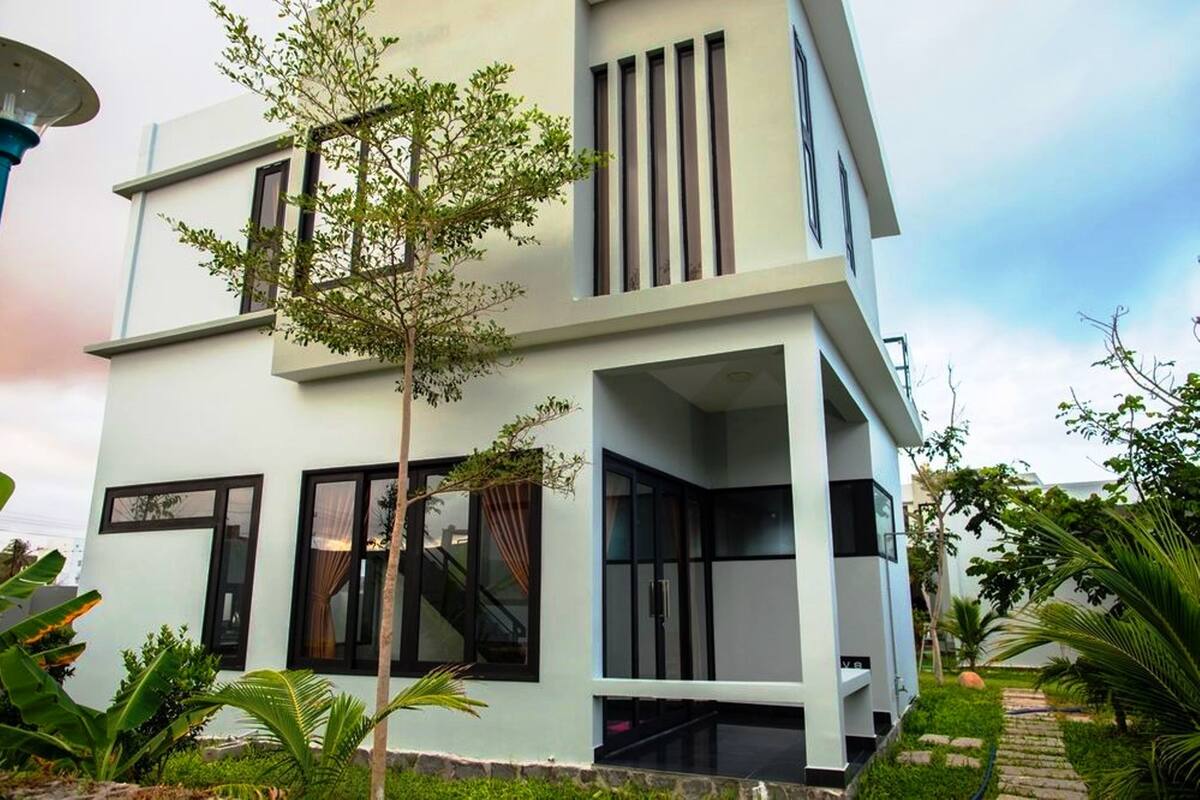 A modern two-story building with large windows and a staircase leading to the upper floor.