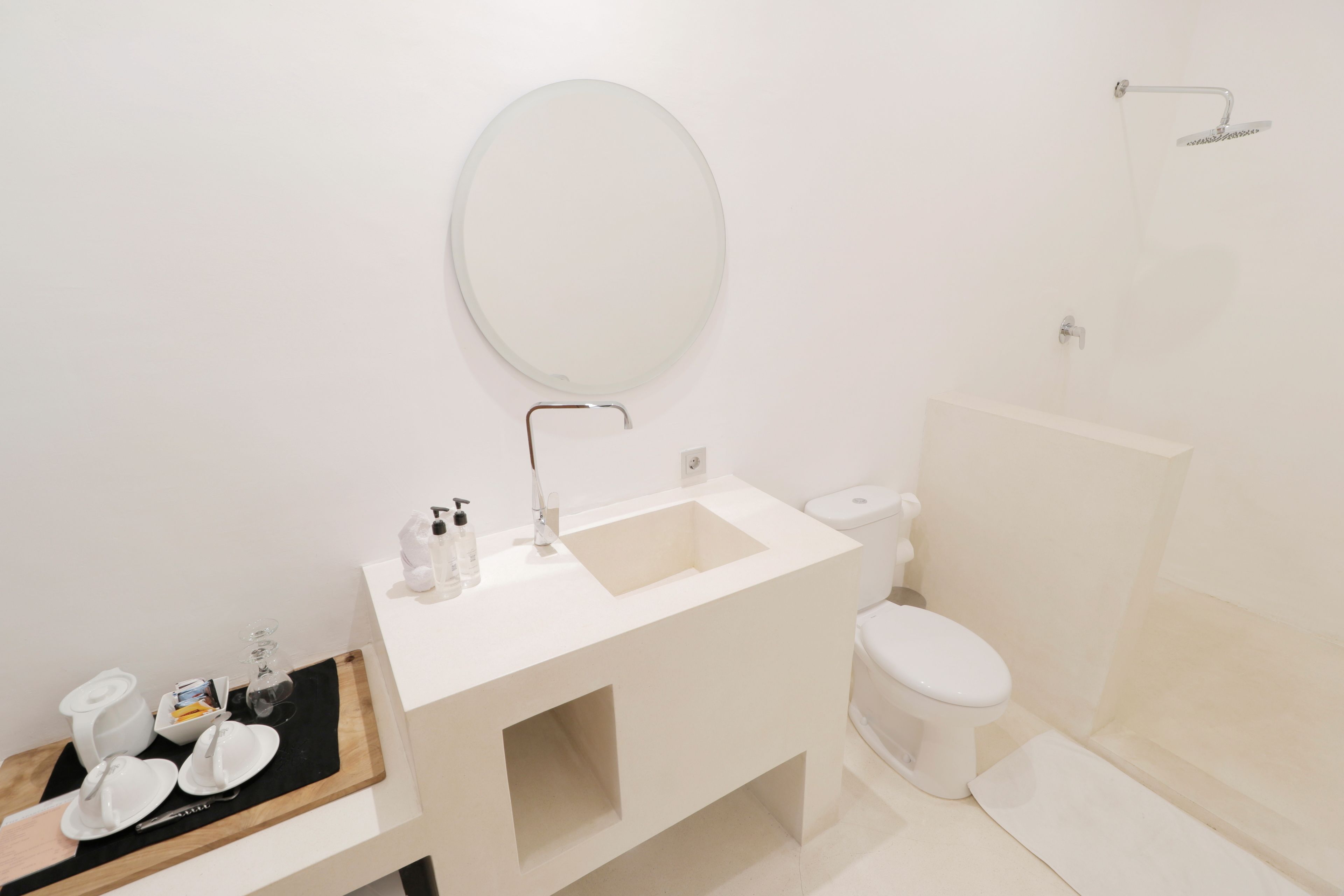 Een moderne badkamer met een wit wastafelmeubel, spiegel en toilet.