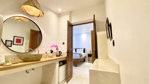 A modern bathroom with a large mirror, a bowl sink, and a wooden vanity. - The Apartment Umalas (Keroboken Kelod)