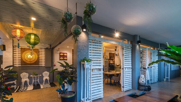 Een modern interieur met een houten plafond, witte meubels en potplanten.