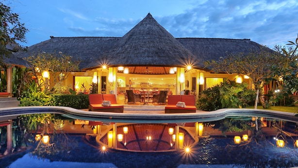 A resort with a pool, thatched-roof building, and outdoor seating area. - Bali Akasa Villa (Seminyak)