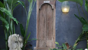 A wooden door with a "STAFF ONLY" sign above it, surrounded by lush green plants. - Bali Akasa Villa (Seminyak)