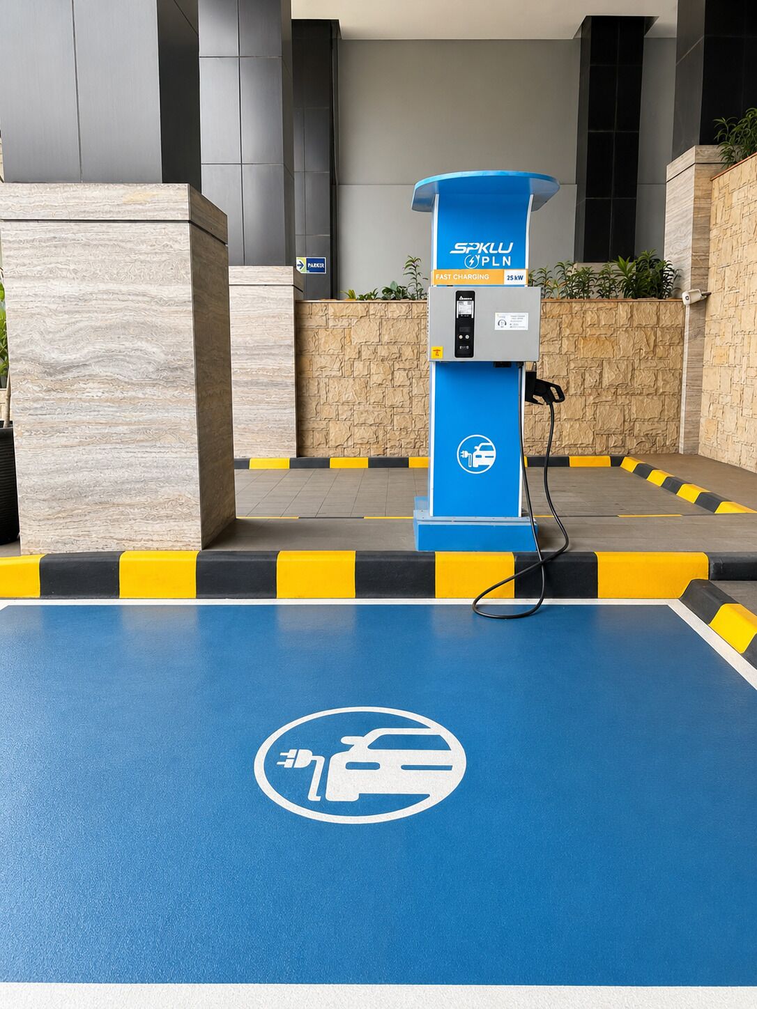A blue electric vehicle charging station with a fast charging label, a charging cable connected, and a parking space marked with a vehicle icon.