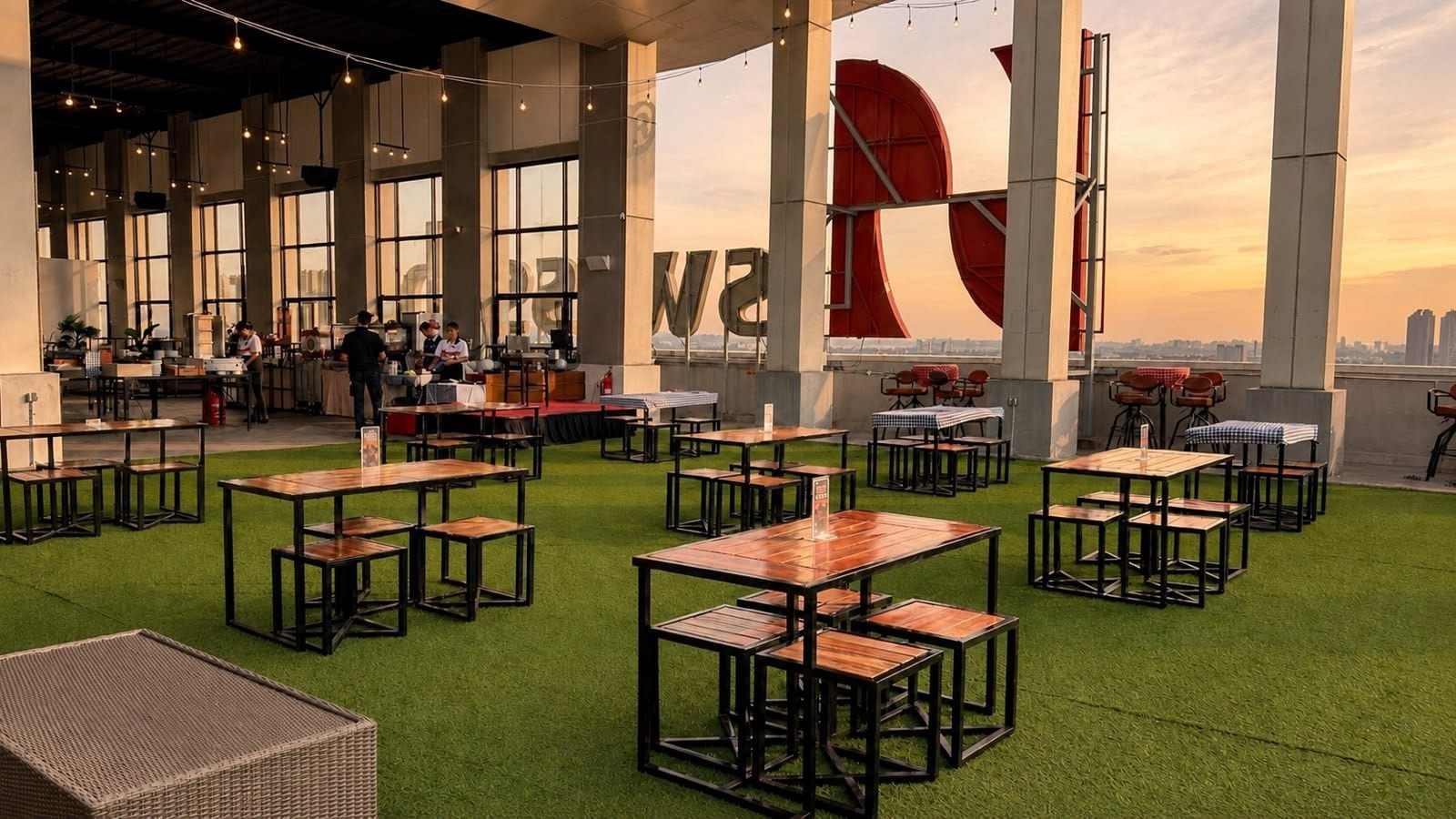 Un comedor interior con mesas y sillas, ventanas amplias y vistas a la ciudad.