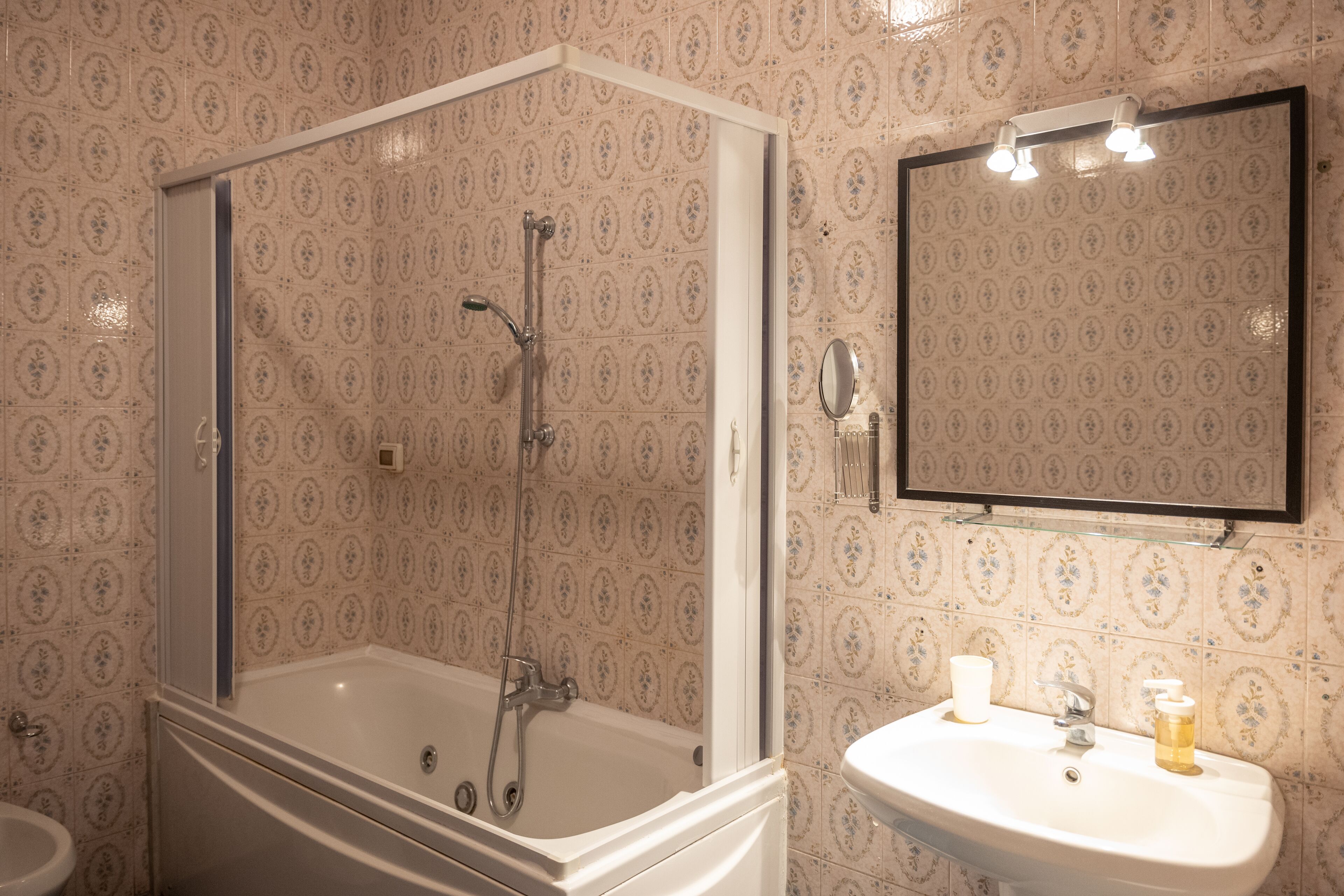 A bathroom with a bathtub, a sink, and a mirror.