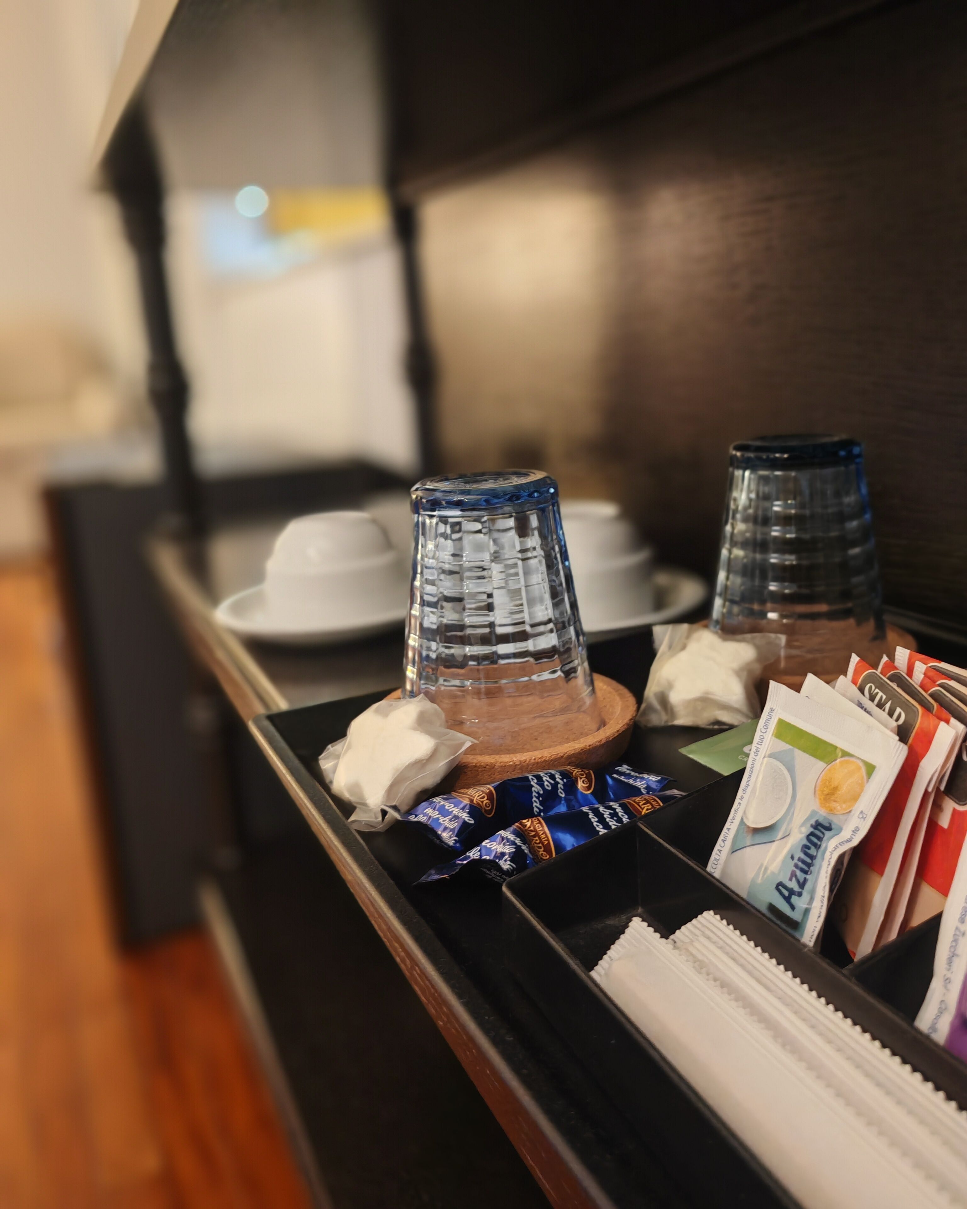 A tray with a glass, a white napkin, and some packaged snacks.