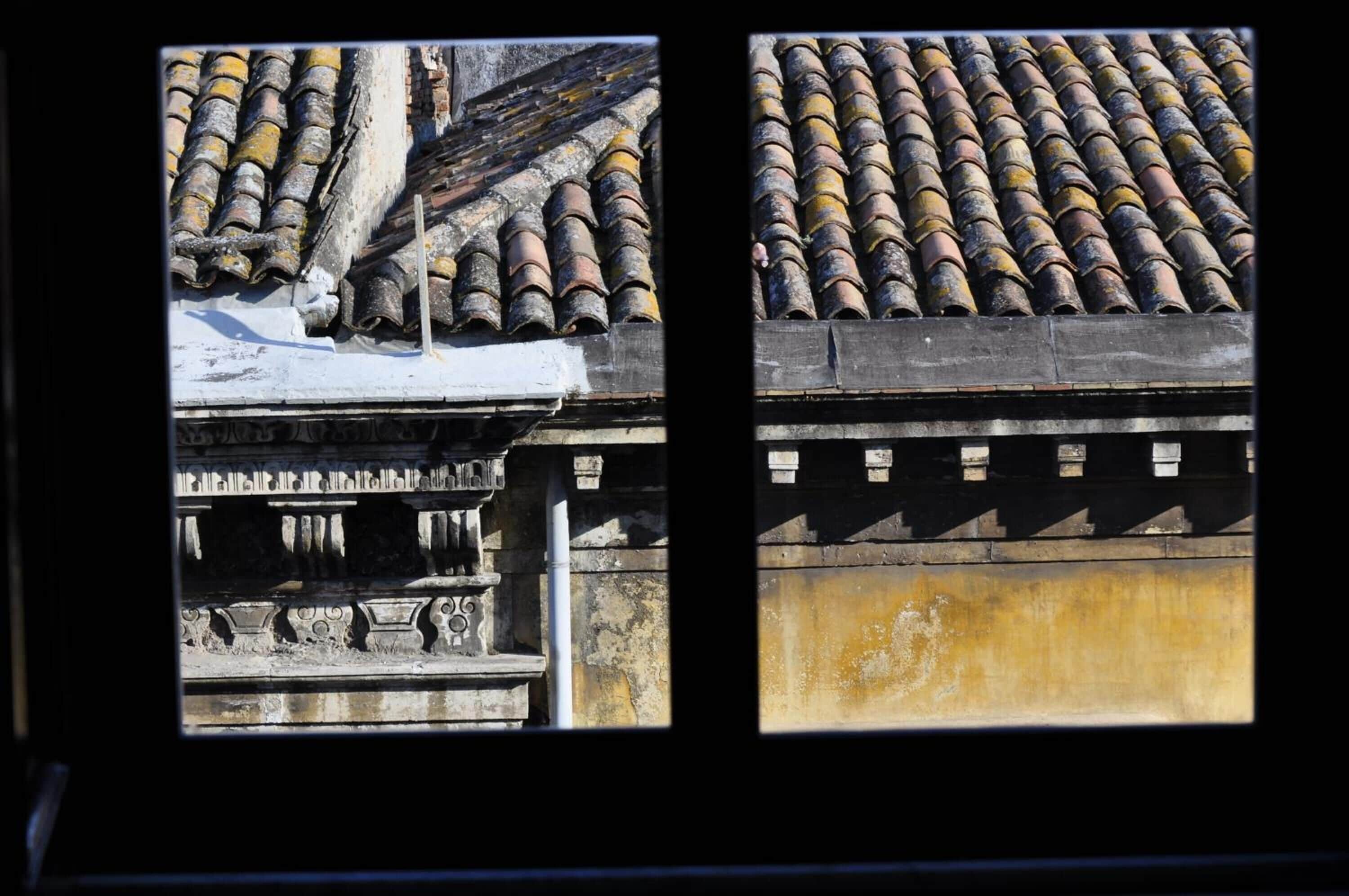A traditional building with a tiled roof and a stone balustrade.