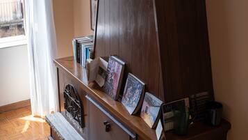 Un mueble de madera con espejo, libros y adornos.